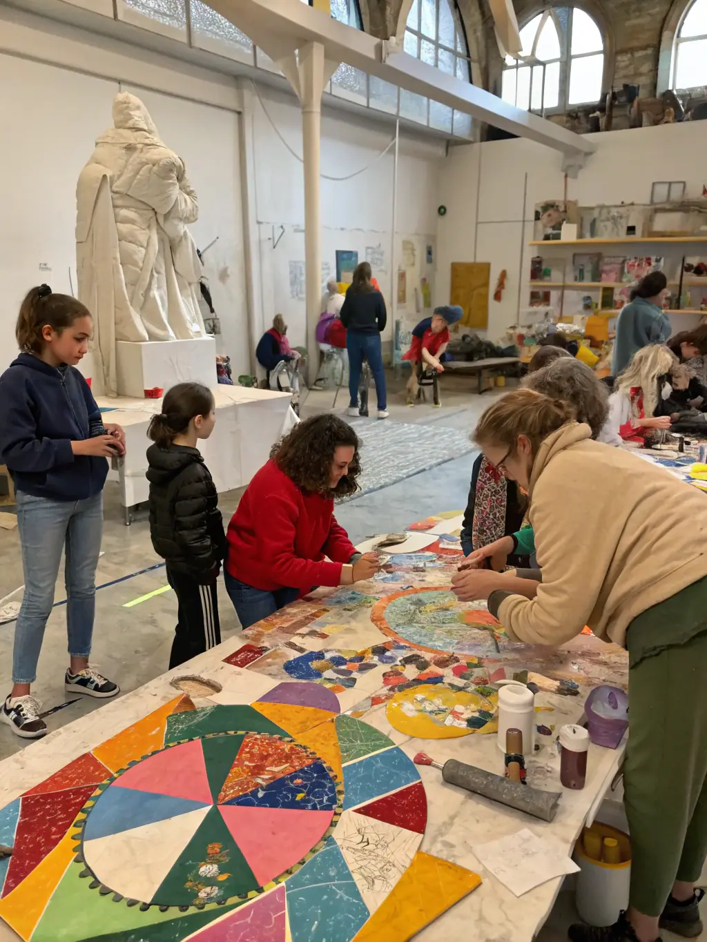 A photograph capturing a diverse group of community members actively participating in a collaborative art project during a PUZZLE CENTRE workshop, showcasing inclusivity and engagement.